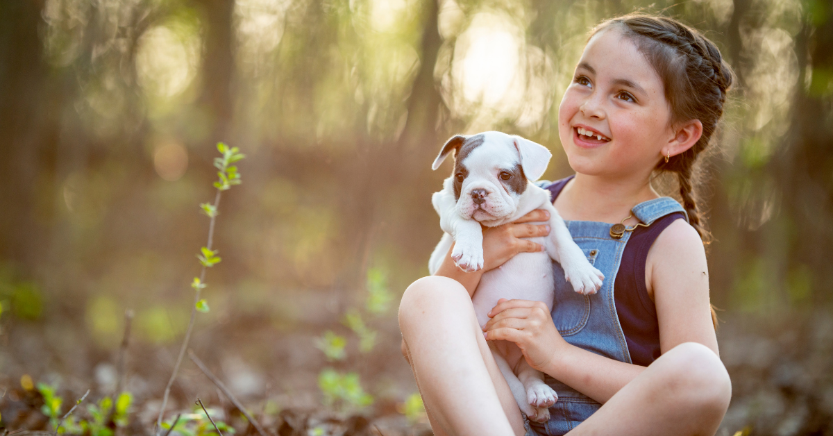 Little girl with her puppy on a dog park in a mobile home community